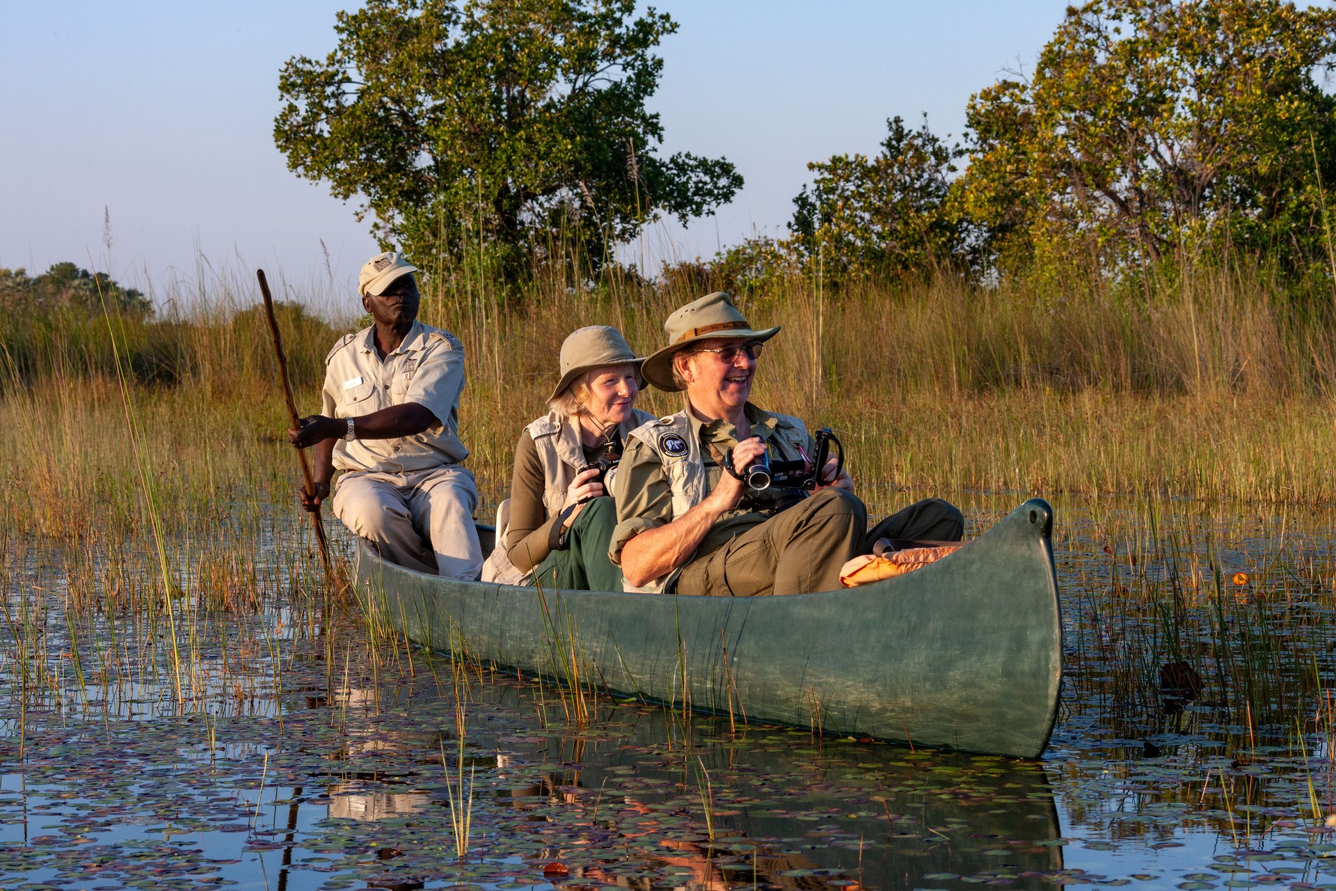 Safari guide with tourists in a Makoro - Okavango Delta - Botswana